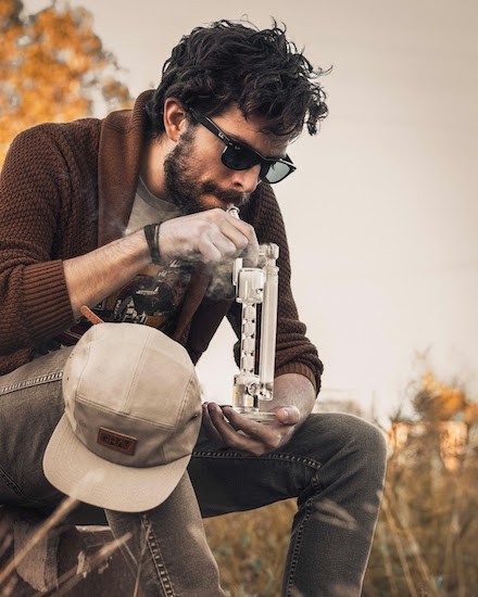 image of a man smoking a bong; demonstrating how to use a bong properly; Photo by Grav on Unsplash
