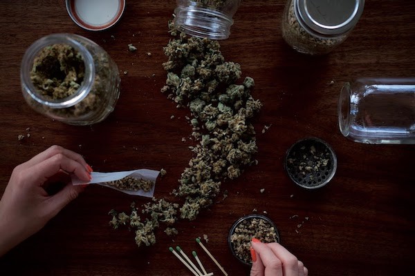image of hands packing and rolling a joint
