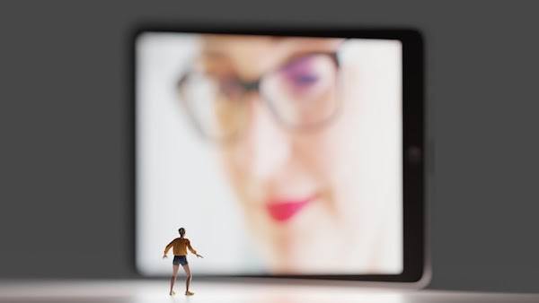 image of tiny figurine looking up at tablet screen; Photo by Thomas Claeys from Unsplashed